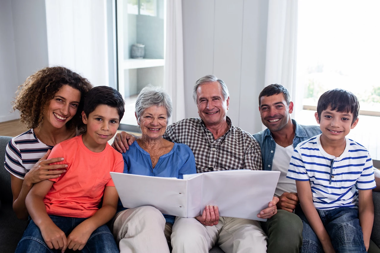 Family sitting on the couch looking through an photo album